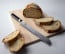 Shun Classic 9 in. (230mm) Bread Knife shown on cutting board with bread