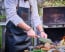 F. Dick Black Leather Apron shown with person cooking