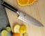 Shun Classic 8 in. HG Chef Knife shown with cutting board and fruit