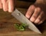 Shun Premier 6 in. (150mm) Chef Knife shown cutting herbs