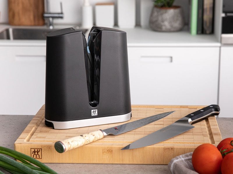 The Zwilling V Edge Sharpener with a birchood and zwilling knife.