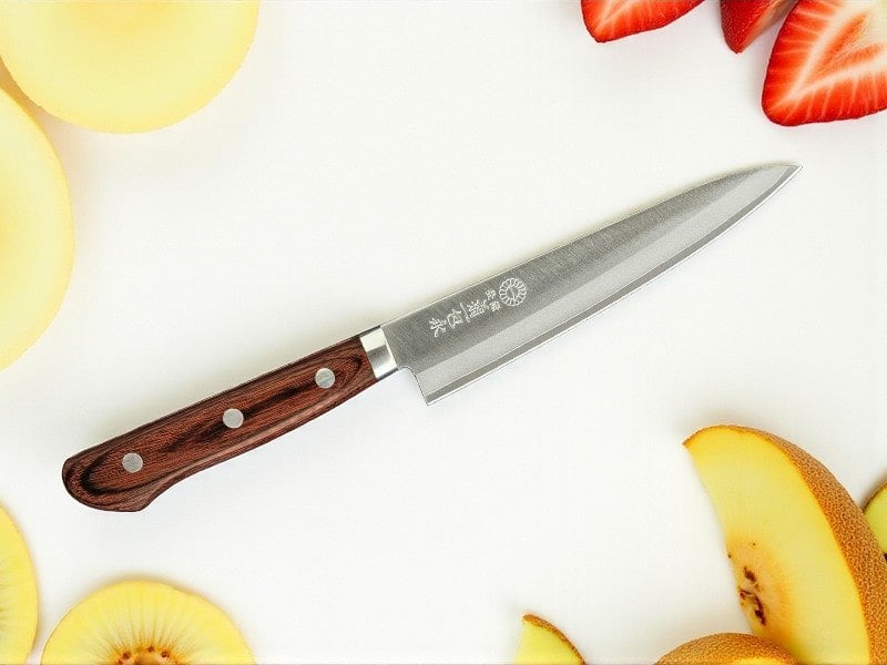 A Kikuichi Warikomi Gold petty knife with fruit